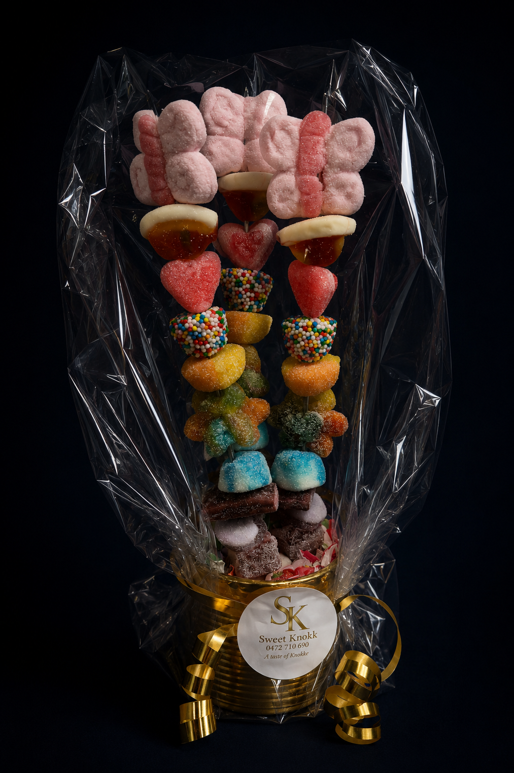 Très joli pot doré composé de 3 brochettes de bonbons